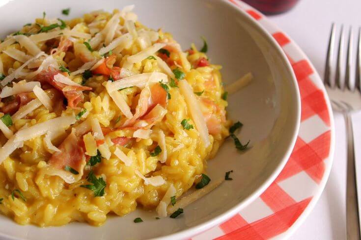 Risotto cremoso alla birra analcolica chiara con speck croccante e timo fresco.